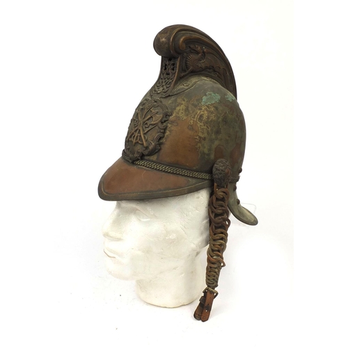 122 - Plated copper Fireman's helmet with applied crest and chin strap, the high comb with dragon decorati... 