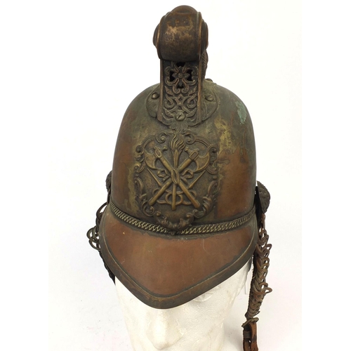 122 - Plated copper Fireman's helmet with applied crest and chin strap, the high comb with dragon decorati... 