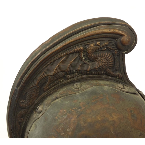 122 - Plated copper Fireman's helmet with applied crest and chin strap, the high comb with dragon decorati... 