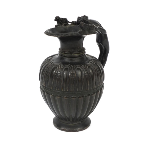 129 - Victorian bronze pitcher with figural handle and fluted body, 11cm high