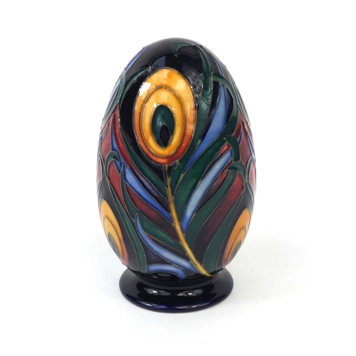 2070 - Moorcroft pottery egg shaped paper weight hand painted and tube lined with stylised peacock feathers... 