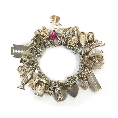 2494 - Heavy silver charm bracelet with a large selection of mostly silver charms including animals, wish b... 