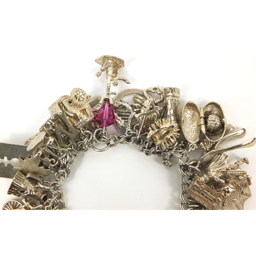 2494 - Heavy silver charm bracelet with a large selection of mostly silver charms including animals, wish b... 