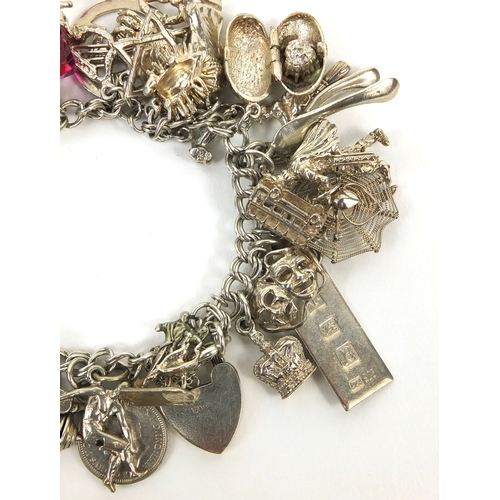 2494 - Heavy silver charm bracelet with a large selection of mostly silver charms including animals, wish b... 