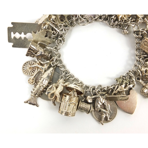 2494 - Heavy silver charm bracelet with a large selection of mostly silver charms including animals, wish b... 