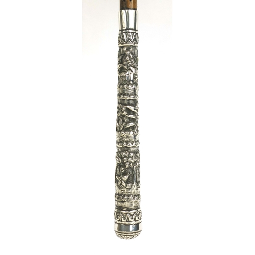 43 - Wooden parasol with silver handle, profusely embossed with Oriental figures in a village amongst flo... 