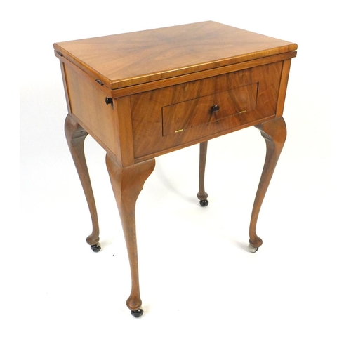 17 - Walnut sewing machine table raised on cabriole legs housing a Viking sewing machine, 85cm high