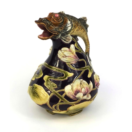 617 - Art Nouveau Majolica jug decorated with stylised flowers, the handle modelled as a leaping fish, imp... 