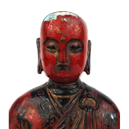 466 - Chinese seated metal Buddha painted in iron red, 29cm high