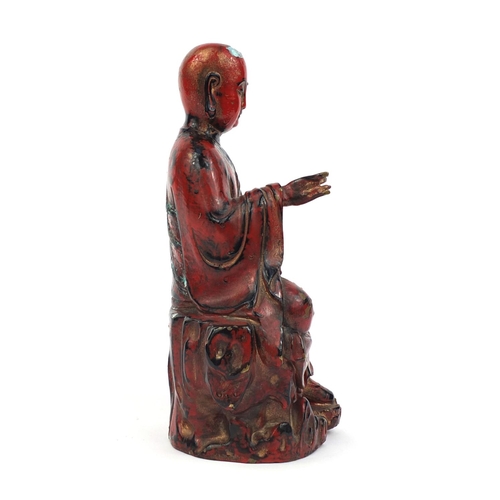 466 - Chinese seated metal Buddha painted in iron red, 29cm high