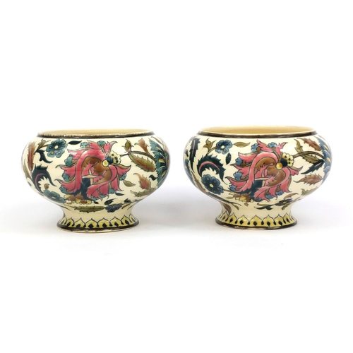 614 - Pair of Zsolnay Pecs oil lamp fonts, both hand painted with stylised flowers, factory marks to the b... 