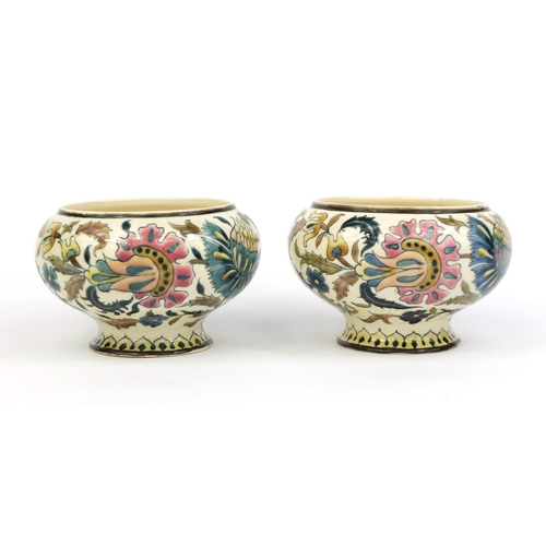 614 - Pair of Zsolnay Pecs oil lamp fonts, both hand painted with stylised flowers, factory marks to the b... 