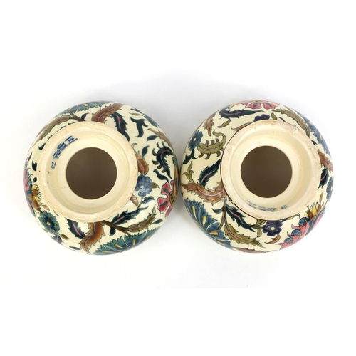 614 - Pair of Zsolnay Pecs oil lamp fonts, both hand painted with stylised flowers, factory marks to the b... 