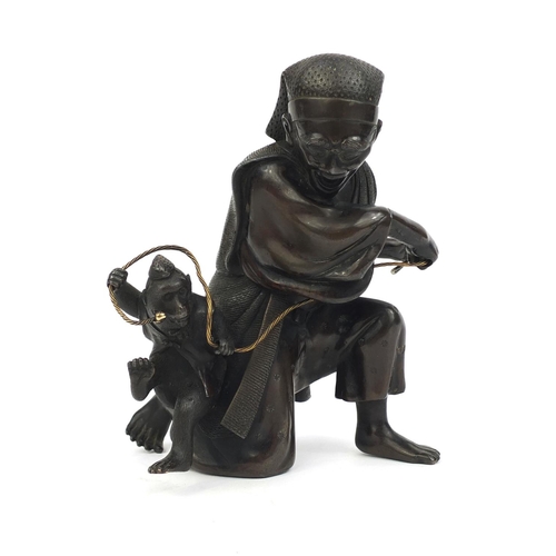 464 - Japanese bronze study of man playing with a monkey, 14.5cm high