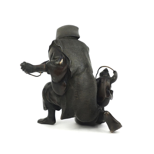 464 - Japanese bronze study of man playing with a monkey, 14.5cm high