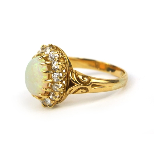 777 - Unmarked gold opal and diamond ring set with an oval cabochon opal surrounded by fourteen diamonds, ... 