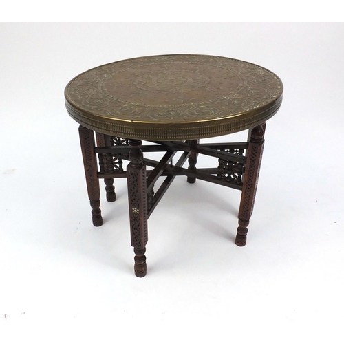 54 - Folding carved wooden table with decorative circular brass top decorated with elephants