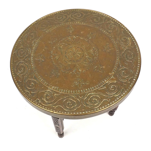 54 - Folding carved wooden table with decorative circular brass top decorated with elephants