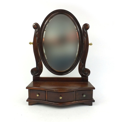 7 - Mahogany oval swing mirror with serpentine fronted jewellery drawers, 58cm high