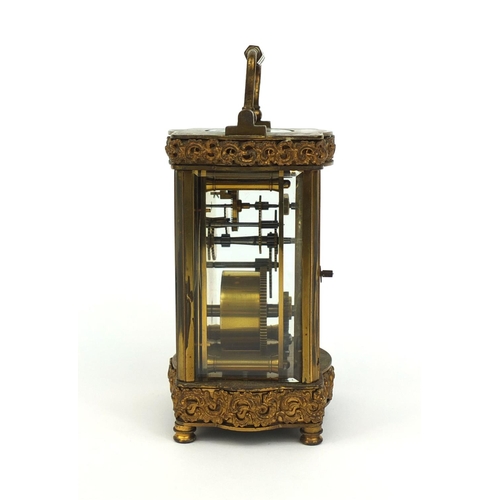 746 - Brass cased carriage clock with bevelled glass, decorated with foliate scrolls, the enamelled chapte... 