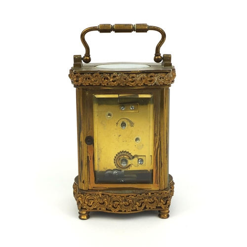 746 - Brass cased carriage clock with bevelled glass, decorated with foliate scrolls, the enamelled chapte... 