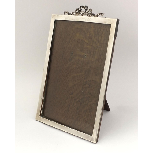 660 - Large rectangular silver easel photo frame with bow crest, M & S Birmingham 1905, 27cm high