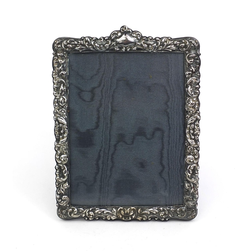 679 - Rectangular silver mounted easel photo frame with embossed floral decoration and blank cartouche, Lo... 