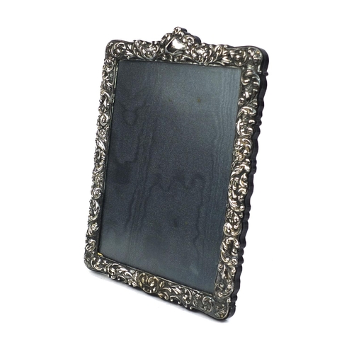 679 - Rectangular silver mounted easel photo frame with embossed floral decoration and blank cartouche, Lo... 