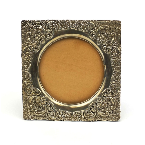 669 - Square silver easel photo frame, profusely embossed with floral decoration, H M Birmingham 1900, 19c... 