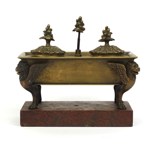 10 - Continental bronze twin inkwell with giffin supports, raised on a red marble base, 15cm high x 17cm ... 