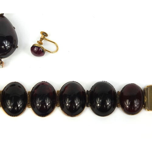 768 - Gilt metal cabochon garnet bracelet, pendant and earrings, the pendant set with seed pearls on a gil... 