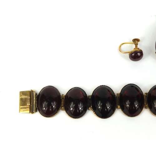 768 - Gilt metal cabochon garnet bracelet, pendant and earrings, the pendant set with seed pearls on a gil... 