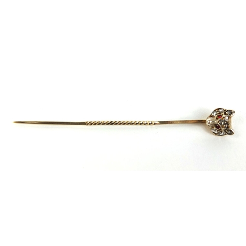 807 - Unmarked gold fox head tie pin set with nine diamonds and ruby eyes, 6.5cm long, approximate weight ... 