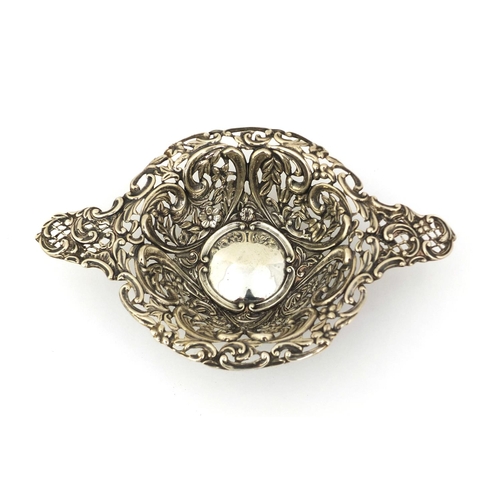 683 - Silver twin handled bon bon dish profusely embossed with flowers and vines and pierced decoration, H... 