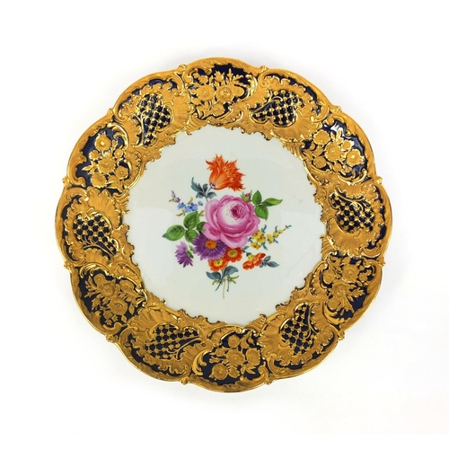 554 - Meissen porcelain cabinet plate hand painted with flowers, within a gilt foliate border onto a cobal... 