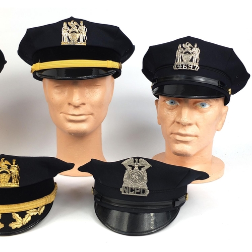 340 - Group of seven American police peak caps all with badges including a New York City Department exampl... 