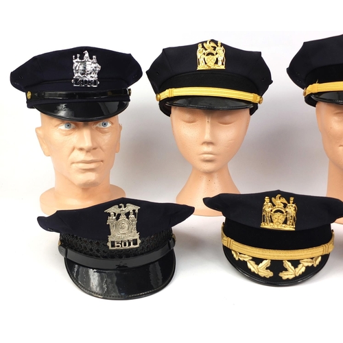 340 - Group of seven American police peak caps all with badges including a New York City Department exampl... 