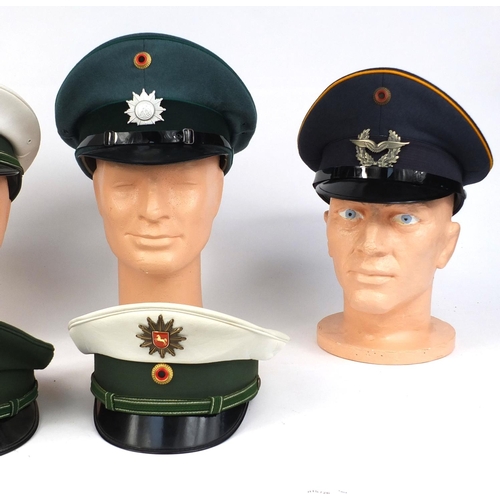 342 - Group of six German police peak caps, each with badges, some with labels to the interior