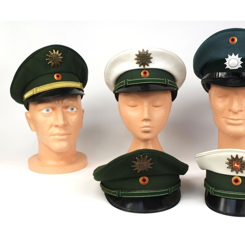 342 - Group of six German police peak caps, each with badges, some with labels to the interior