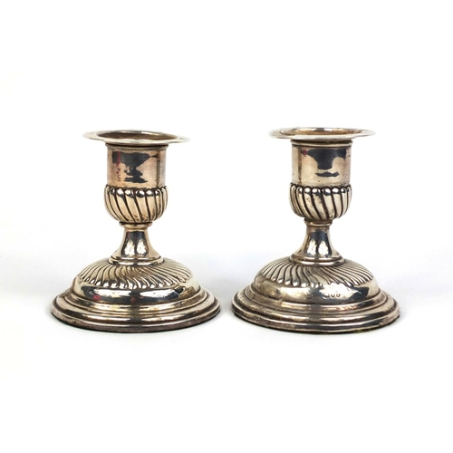 685 - Pair of Victorian silver dwarf candlesticks with demi fluted decoration, E.F.H.T London 1890, 9cm hi... 