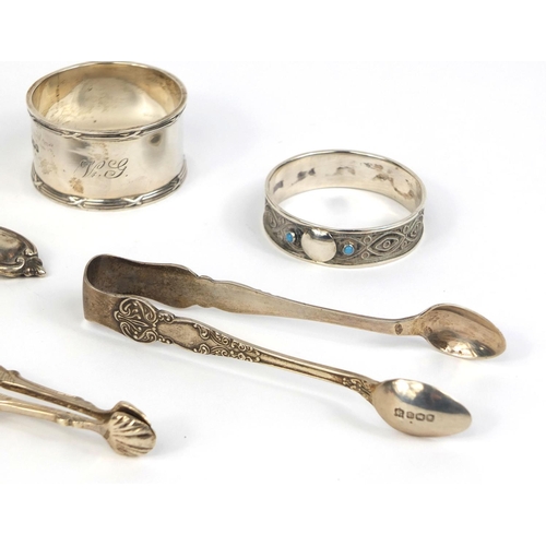 732 - Silver items comprising pair of sugar nips, pair of sugar tongs, straining spoon and two napkin ring... 