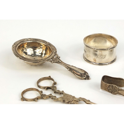 732 - Silver items comprising pair of sugar nips, pair of sugar tongs, straining spoon and two napkin ring... 