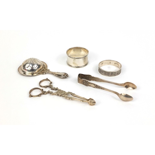 732 - Silver items comprising pair of sugar nips, pair of sugar tongs, straining spoon and two napkin ring... 