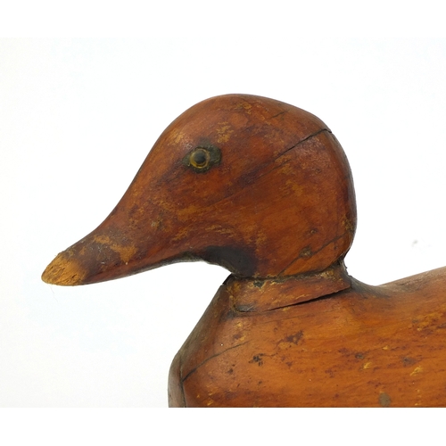 112 - Two carved wooden duck decoys, one impressed Victor to the base, the largest 40cm long