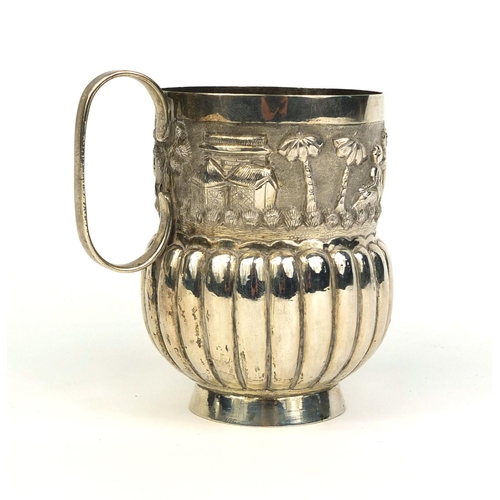 514 - Middle Eastern unmarked silver beaker, embossed with a continuous band of village scene, 9.5cm high,... 