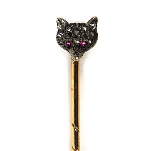 829 - Unmarked gold fox head tie pin set with fourteen diamonds and ruby eyes, 6cm long, approximate weigh... 