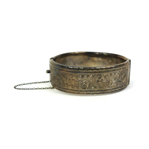 844 - Heavy silver bangle with engraved floral decoration, 7cm long x 2.2cm wide, approximate weight 60.5g