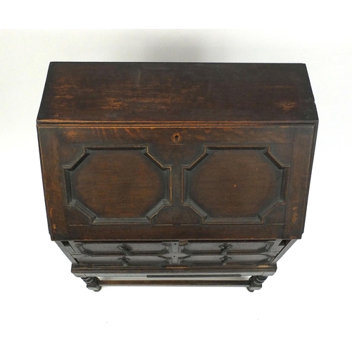 71 - Carved oak bureau fitted with a fall above two drawers, 101cm high x 73cm wide x 43cm deep