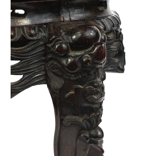 473 - Chinese hardwood stand with marble inset top, above a pierced frieze, the legs carved with mythical ... 