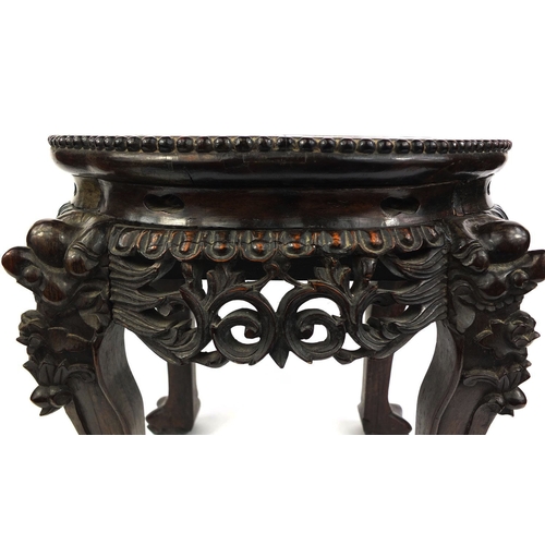 473 - Chinese hardwood stand with marble inset top, above a pierced frieze, the legs carved with mythical ... 